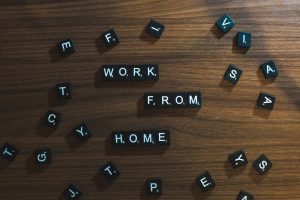 Square black and white letters on a brown surface spelling out Work From Home