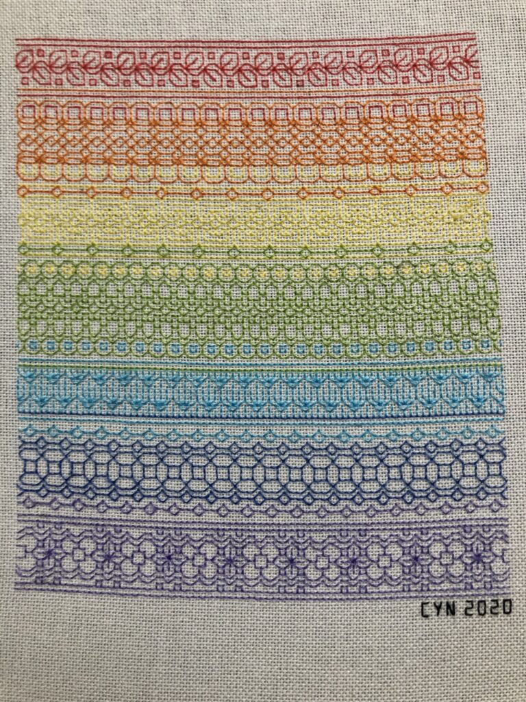 Lines of blackwork stitches in a rainbow of colors